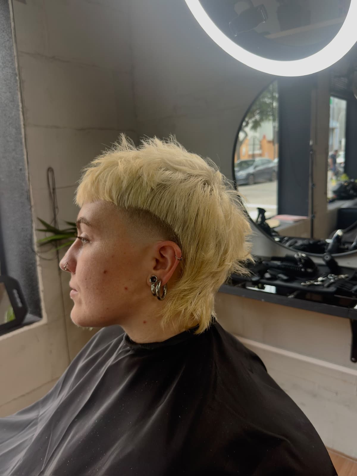 Mullet rubio platino con fade lateral, en la silla del estudio